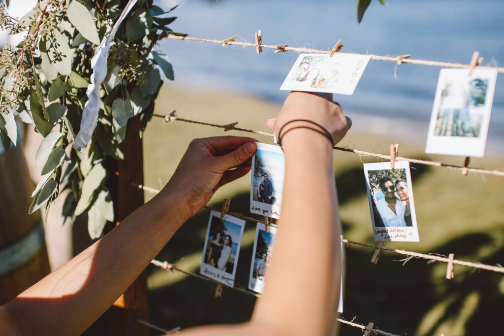 person hanging the photos using wooden clothespins
