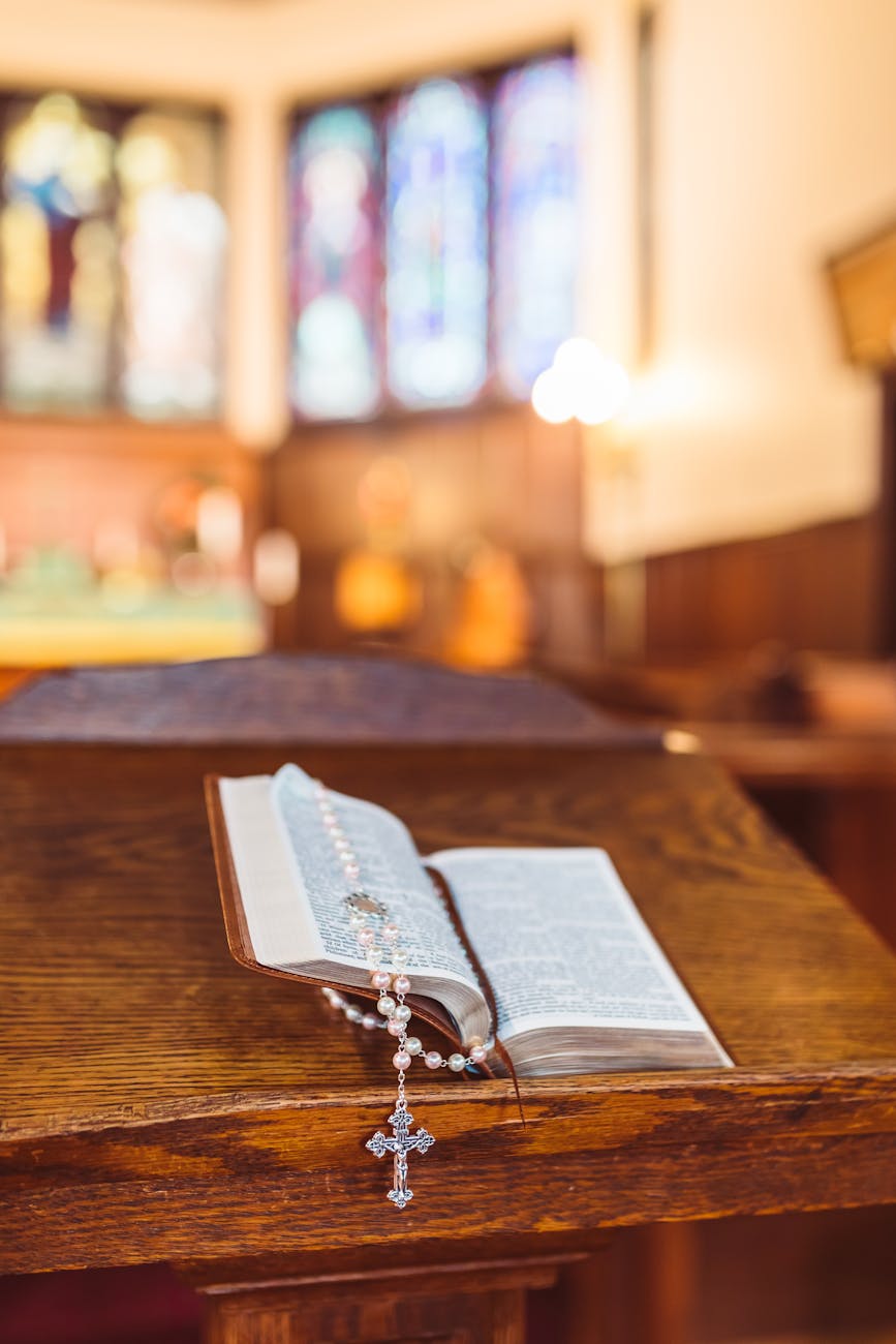 holy book with rosary on brown wooden table